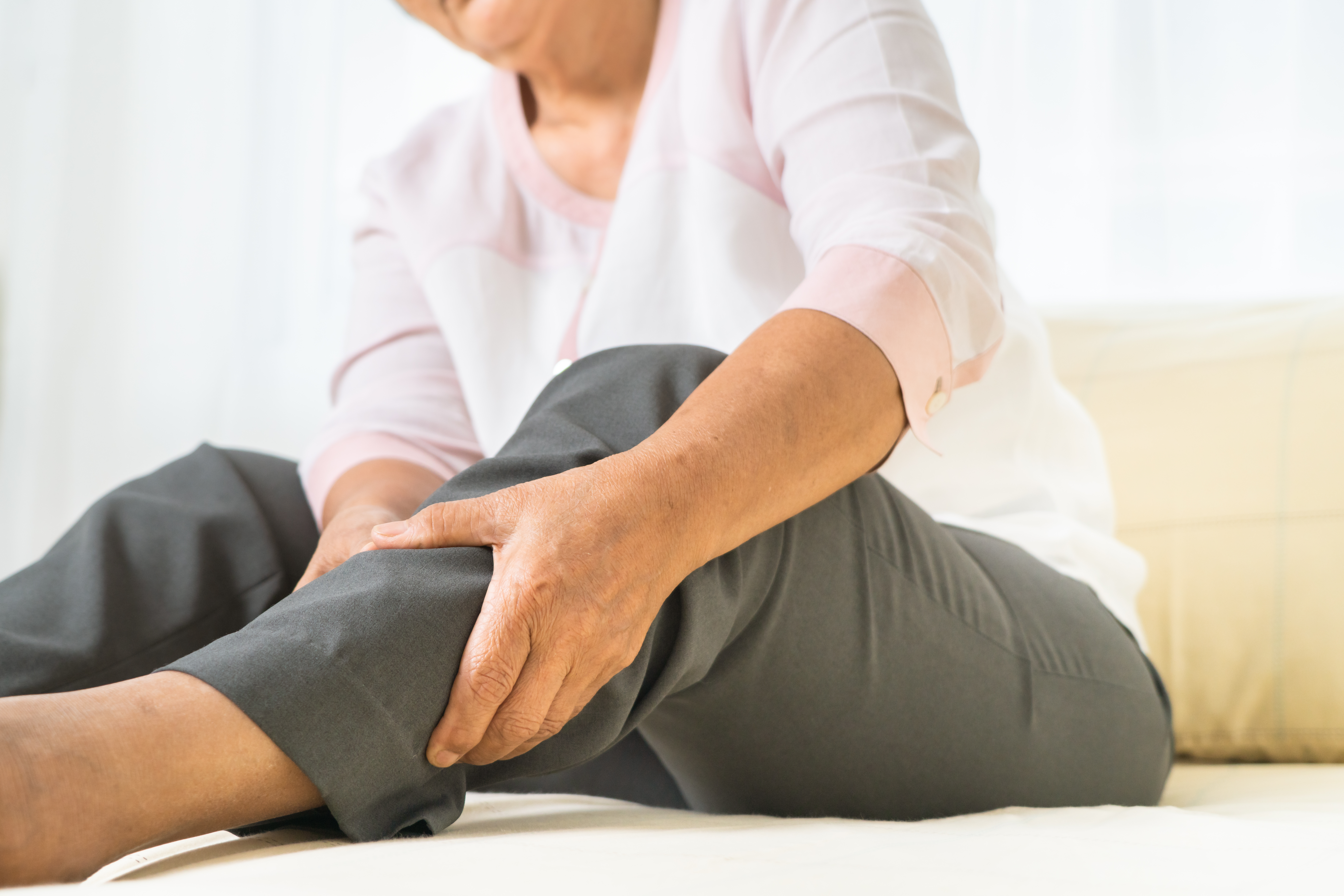 Elderly women rubs her leg in pain
